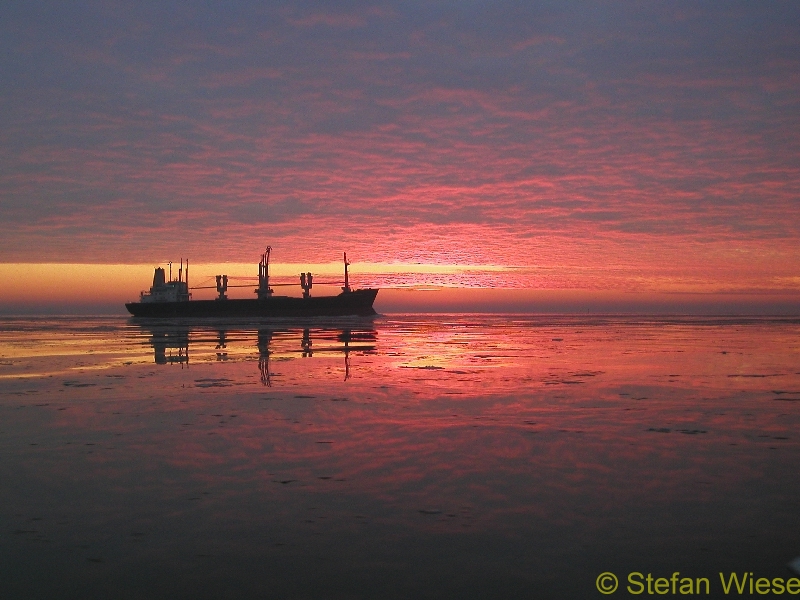 Sonnenaufgang-Sonnenuntergang (Sonnenaufgang im Winter mit Schiff im Hintergrund)